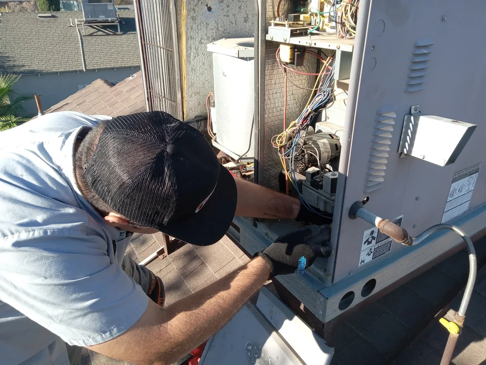 Heritage Mechanical technician performing attic HVAC service